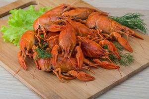Boiled crayfish on wooden board and wooden background photo