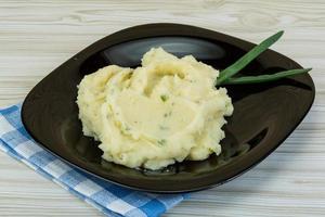 Mash potato on the plate and wooden background photo