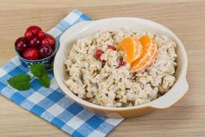 Oatmeal in a bowl on wooden background photo