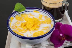 Cornflakes in a bowl on wooden background photo