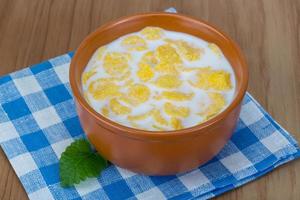 Cornflakes in a bowl on wooden background photo