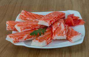 Crab sticks on the plate and wooden background photo