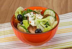 Greek salad in a bowl on wooden background photo