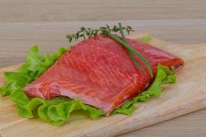 Salmon on wooden board and wooden background photo