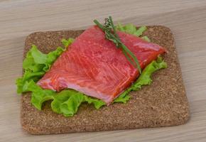 Salmon on wooden board and wooden background photo