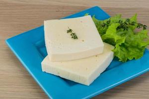 Yellow cheddar on the plate and wooden background photo