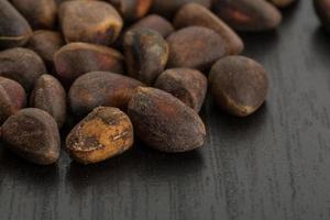 Cedar nuts on wooden background photo