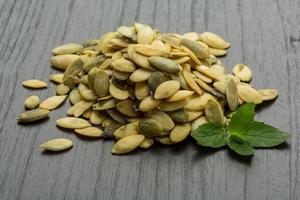 Pumpkin seeds on wooden background photo