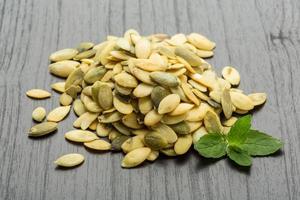 Pumpkin seeds on wooden background photo