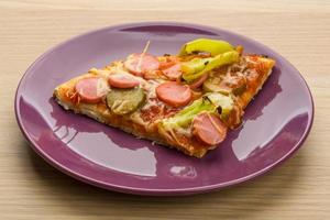 Pizza on the plate and wooden background photo