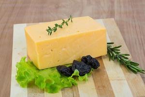 Yellow cheese on wooden board and wooden background photo