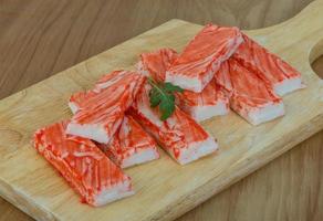 Crab sticks on wooden board and wooden background photo