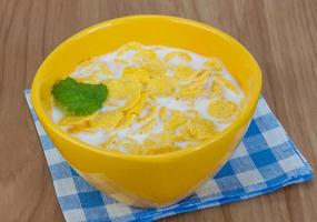 Cornflakes in a bowl on wooden background photo