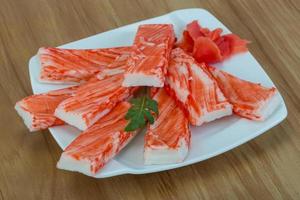 Crab sticks on the plate and wooden background photo