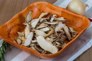 Dry shiitake in a bowl on wooden background photo