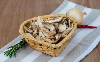 Dry shiitake in a basket on wooden background photo