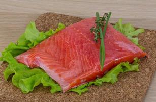 Salmon on wooden board and wooden background photo