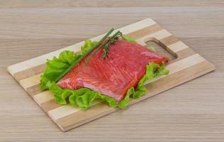 Salmon on wooden board and wooden background photo