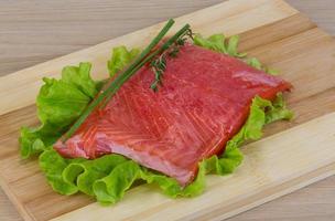 Salmon on wooden board and wooden background photo