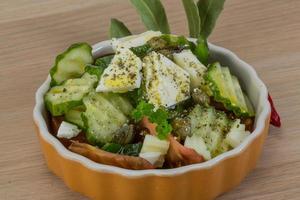 Greek salad in a bowl on wooden background photo