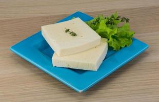 Yellow cheddar on the plate and wooden background photo