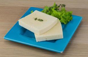 Yellow cheddar on the plate and wooden background photo