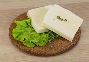 Yellow cheddar on wooden board and wooden background photo