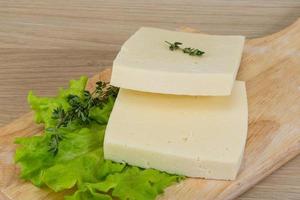 Yellow cheddar on wooden board and wooden background photo