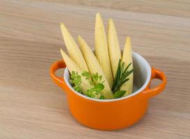 Baby corn in a bowl on wooden background photo