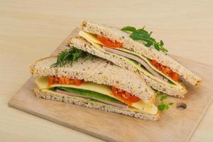 Club sandwich on wooden board and wooden background photo