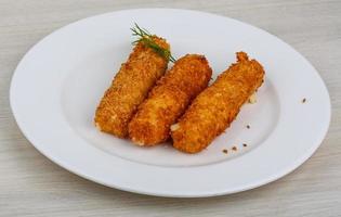 Fried cheese on the plate and wooden background photo