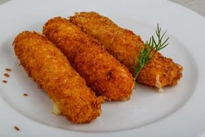 Fried cheese on the plate and wooden background photo