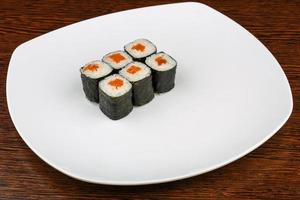 Salmon maki on the plate and wooden background photo