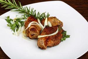 Grilled pork on the plate and wooden background photo