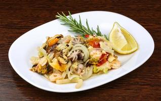 Seafood cocktail on the plate and wooden background photo