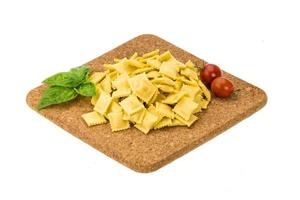Ravioli on wooden board and white background photo