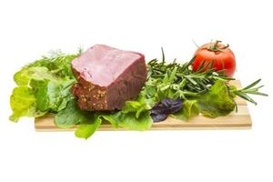 Smoked beef on wooden board and white background photo