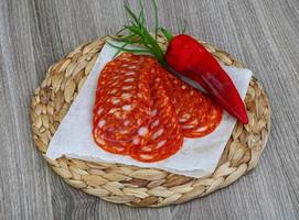 Chorizo on wooden board and wooden background photo