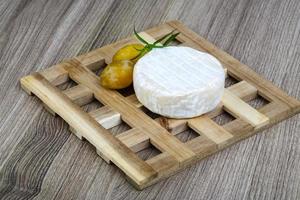 Brie cheese on wooden board and wooden background photo