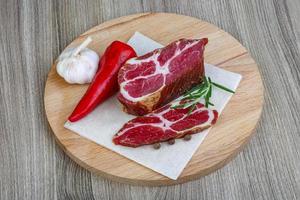 Chuck steak on wooden board and wooden background photo