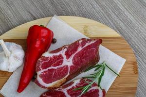 Chuck steak on wooden board and wooden background photo