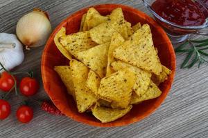 nachos en un bol sobre fondo de madera foto