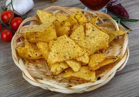 Nachos in a basket on wooden background photo