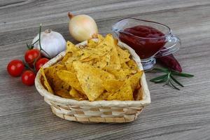 Nachos in a basket on wooden background photo