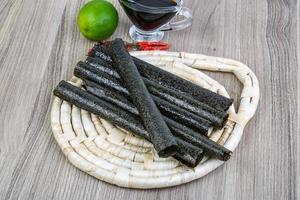 Seaweed rolls on wooden board and wooden background photo