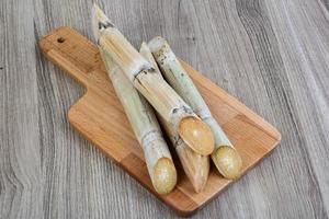 palitos de azúcar en tablero de madera y fondo de madera foto