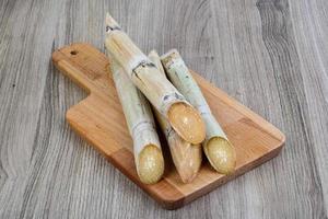 Sugar sticks on wooden board and wooden background photo