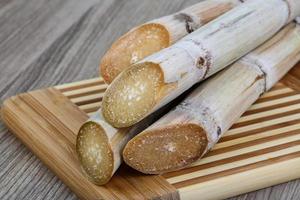 palitos de azúcar en tablero de madera y fondo de madera foto