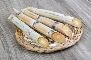 palitos de azúcar en tablero de madera y fondo de madera foto