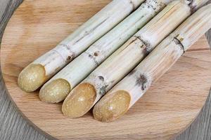 palitos de azúcar en tablero de madera y fondo de madera foto